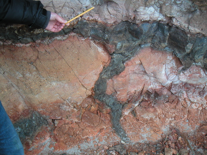 This is pretty nice - a cross-section of magma that was pushed up through the orange rock to form a dike (the vertical part) turning into a sill (the horizontal part).