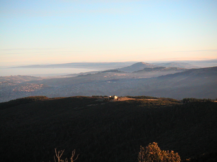 Evening fog coming in and a lonely house on a ridge