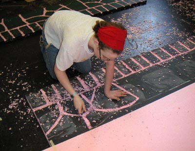 Sarah carves rocks out of foam.